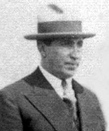 Black and white photo of a man wearing a suit and a hat