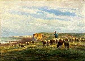 Rural landscape with grassy cliff top to the right, sea and shore in the background to the left. Shepherd in a blue smock stands on cliff top to the right, leaning on his staff, with a flock of sheep grazing around him.