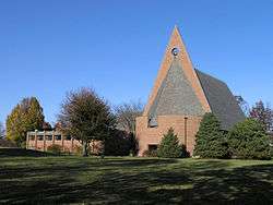 Red brick church with triangular facade and tall, sloping roof