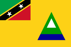 The Nevis flag incorporates the flag of the Federation of Saint Kitts and Nevis in the top left corner. The golden field stands for sunshine. The central triangle represents the conical shape of Nevis, with the blue being the ocean; the green being the verdant slopes of the island; and the white being the clouds that usually wreathe Nevis Peak