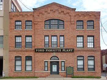 A large brick building with a sign that says Ford Piquette Plant