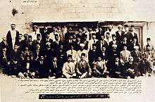 Large group of men, with Arabic caption
