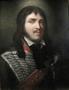 Painting of a young man in a hussar uniform. He wears a moustache and brown hair past his shoulder.