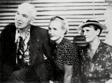 Young woman (center) with older man and woman sitting on each side of her