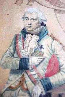 Detail from a painting shows a calm-looking man from head to the top of his thighs. On his head he has a late 18th century-style white wig with the hair curled over the ears. He wears a white military uniform with navy blue lapels and cuffs with a red and white sash across his shoulder.