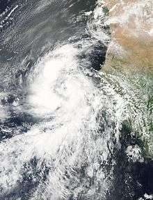 A satellite image shows Fred as a tropical storm, situated right between the Cape Verde Islands and the coast of West Africa. The storm is supporting thick thunderstorm clouds, arranged in two prominent bands.