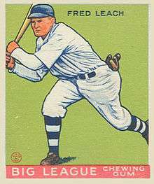 A baseball card image of a man in a white baseball uniform and blue baseball cap swinging a baseball bat