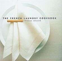 The cover of The French Laundry Cookbook depicts a white napkin folded on a white plate.