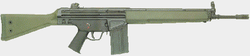 A green Heckler & Koch G3A3 battle rifle lain on a grey background, pointing to the viewer's right