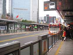 Passengers and a bus at a station