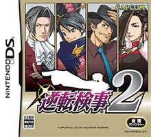 The box art shows four tall rectangles on a beige background; each rectangle frames an illustration of one the game's characters. The game's logo consists of the text "Gyakuten Kenji" written in purple using Japanese characters, followed by a large, gray number "2". Extending upward from the Japanese characters is a white silhouette of Miles Edgeworth extending his arm to the left and pointing with his index finger.