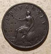 A worn copper coin with Britannia on it