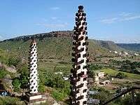 Two tall, narrow monuments with black stones on their sides