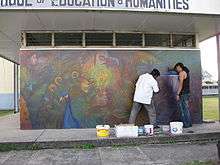 Photograph of George Simon and Anil Roberts at work on the Palace of the Peacock mural at the University of Guyana (2009)