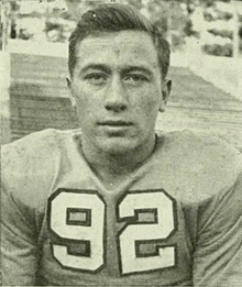An American football player looking at the camera while wearing his jersey.