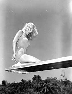 Portrait of Ginger Stanley sitting on a diving board, Weeki Wachee Springs, Florida, taken in 1951
