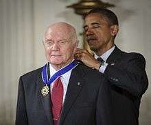 Barack Obama putting on Glenn's Medal of Freedom from behind