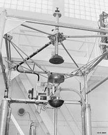 Complex scientific apparatus with metal frame surrounding three sections of a sphere held in the center by a system of rods, and separated vertically from one another so as to form a sphere when brought together