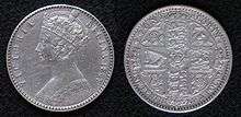 Both sides of a silver coin, with a crowned woman on one side and shields on the other