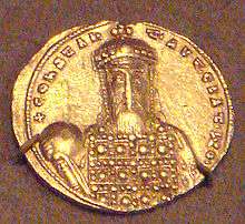 A coin depicting a bearded man wearing a crown