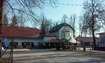 Rustic buildings, with a paved area in the foreground