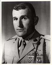 A black and white image of Graham wearing his military uniform with ribbons and badges without a hat.