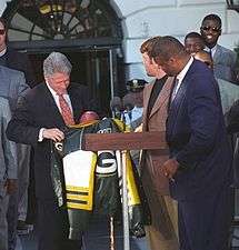 A photo of Reggie White and other Packers players with former president Bill Clinton