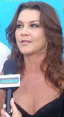 A woman with long dark hair talking into a microphone