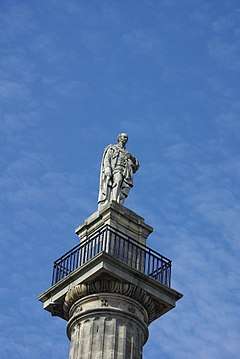 A statue of Charles Grey stands atop of 40-metre-high pillar, against the backdrop of a blue sky.