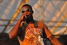Gucci Mane performing in Williamsburg, Brooklyn, on August 29, 2010. He is rapping into his microphone.