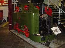 A small green tank steam locomotive of unusual design, number 13, stands in the museum. The power to the wheels comes from a crank-shaft at the upper rear of the locomotive, which is transmitted to the rear wheel via a vertical connecting rod on the right hand side. The rear wheels are connected to the front wheels by a conventional horizontal connecting rod. A plaque on the front of the locomotive reads WILLIAM SPENCE S. GEOCHECANS PATENT, with a final line obscured by a hand rail rising from the front buffer beam.