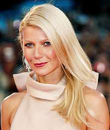 Gwyneth Paltrow—a white female with blue eyes and straight, shoulder-length blonde hair, wearing a cream-colored, high-collared dress—attending the 2011 Venice Film Festival at age 38.