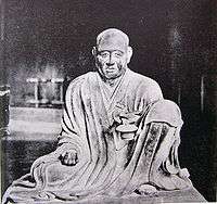  Gyōga. Frontal view of a seated monk with the left leg propped up.