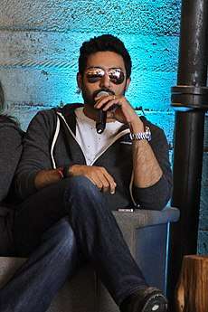Abhishek Bachchan in dark glasses, with a microphone