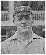 A black and white grainy image of the head and shoulders of a man. He is wearing a flat cricket cap, with three light horizontal swords visible, and a white top.