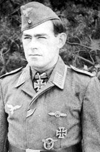 A black and white photo of a man wearing a military uniform with an Iron Cross displayed at the front of his shirt collar.