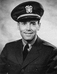 Black-and-white photo of Henry Fonda—a white man in his 40s, wearing Navy uniform, has dark eyes and hair and is smiling.