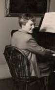 Black and white photograph of Hester Dickson Martineay seated at a piano