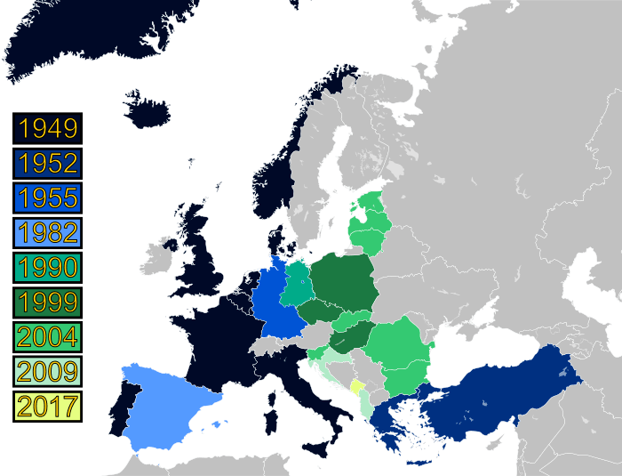 A map of Europe with countries labeled in shades of blue, green, and yellow based on when they joined NATO.