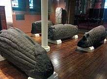 Photo of several sculpted hogback monuments