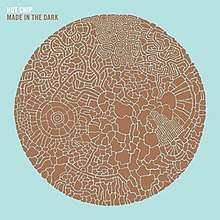 Pale blue album cover embossed with a brown circle made up from smaller parts. The words "Hot Chip" and, below it, "Made in the Dark" are displayed in the top left hand corner.