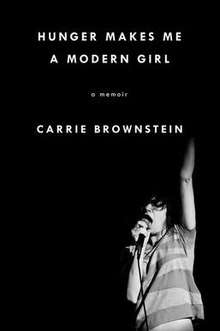 The book's black cover displays the title, "Hunger Makes Me a Modern Girl: A Memoir", and Carrie Brownstein's name in white print at the top of the page; in the lower half, a photo of Brownstein singing into a microphone.