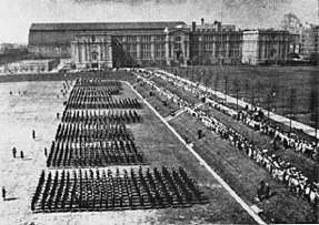 A photograph of Hunter College in the Bronx, New York, the training center for enlisted WAVES, where recruits are marching on the parade grounds.