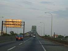 A four-lane freeway ascending onto a continupus arch bridge