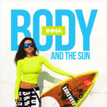 Photograph of Inna wearing a yellow t-shirt along with black sunglasses, holding a surf board in her hands.