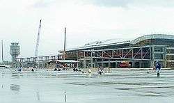 Jet bridges are being constructed from a partially complete terminal building.
