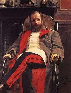 Portrait of a man with a long beard and glasses, wearing a military uniform and sitting in a rocking chair