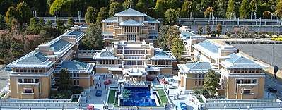A photograph of a scaled down model of a hotel with two building wings either side of a main building with a fountain in front