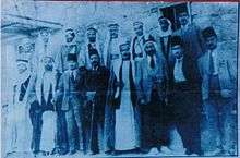 Blue-tinted outdoor photo of a group of men