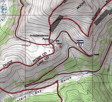A topographic map of the pass showing Highway 82, the Continental Divide and the national forest boundaries in red on a white background with green areas